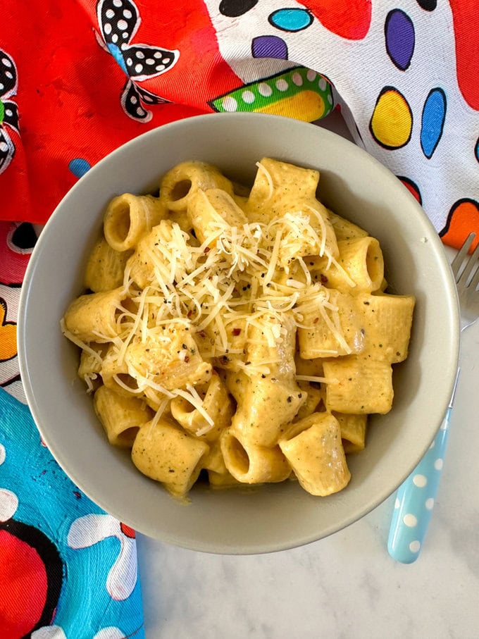 A bowl of airfryer creamy hidden veg pasta garnished with finely grated cheese.