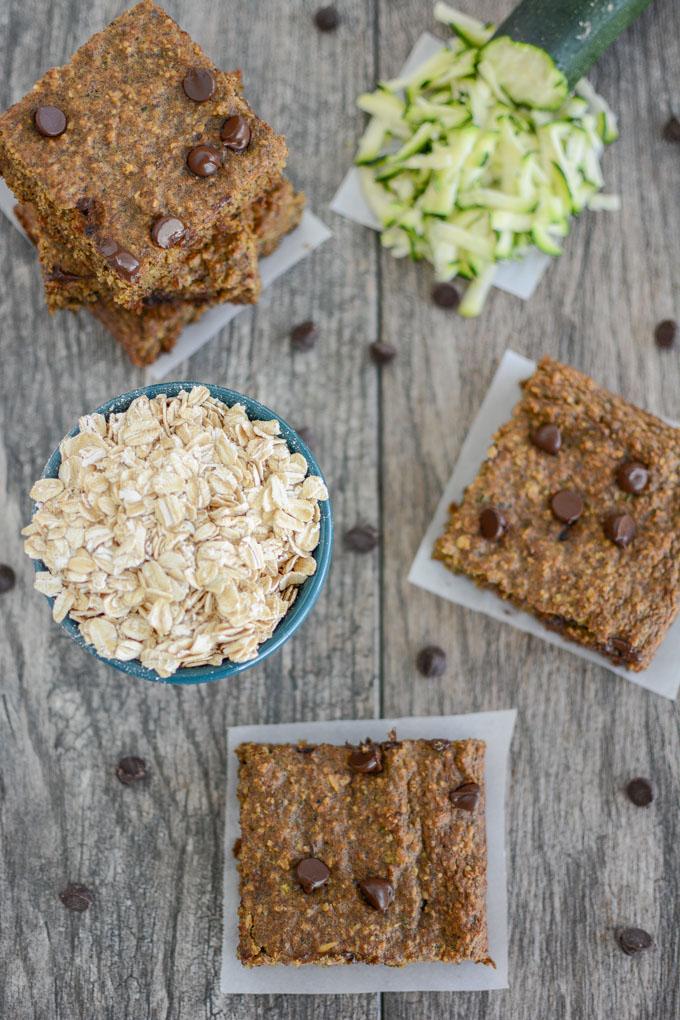 Zucchini Oatmeal Chocolate Chip Bars 29 overhead shot of zucchini oat bars with bowl of oats and shredded zucchini